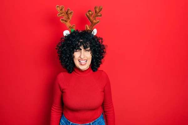若いです中東女性身に着けていますかわいいクリスマストナカイ角ウインク見ますザ カメラとともにセクシー表現 陽気で幸せな顔 — ストック写真