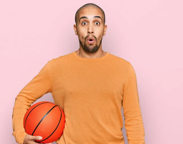 Hispanische Erwachsener Mann Hält Basketballball Verängstigt Und Erstaunt Mit Offenem — Stockfoto