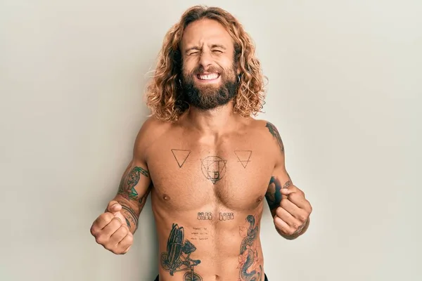 Όμορφος Άνδρας Γενειάδα Και Μακριά Μαλλιά Στέκεται Shirtless Δείχνει Τατουάζ — Φωτογραφία Αρχείου