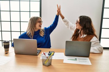 İki iş kadını el kaldırdı ve ofiste beşe vurdu..