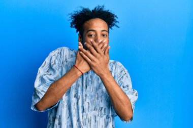 Sıradan kıyafetler giyen Afrikalı Amerikalı genç bir adam ağzını yanlışlıkla elleriyle kapatırken şok geçirdi. gizli kavram. 
