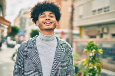 Genç Afrikalı Amerikalı iş adamı şehirde mutlu mesut dikiliyor..