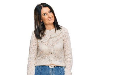 Orta yaşlı esmer kadın gündelik kıyafetler giyiyor. Pozitif ve mutlu görünüyor. Kendine güvenen bir gülümsemeyle dişlerini gösteriyor. 