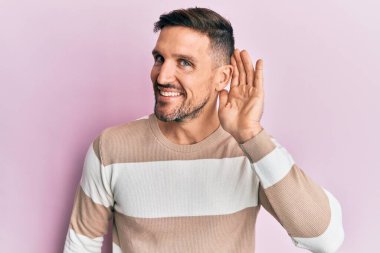 Sakallı, sıradan kıyafetler giyen, kulağı kulağında gülümseyen dedikoduları ve dedikoduları dinleyen yakışıklı bir adam. Sağırlık kavramı. 