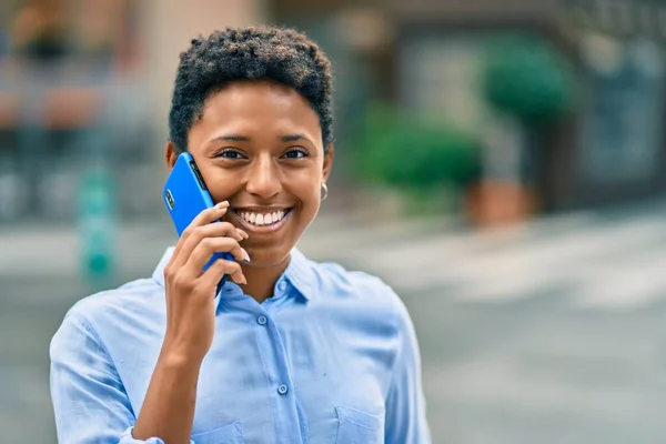 若いアフリカ系アメリカ人の女の子が笑顔で市内のスマートフォンで話しています — ストック写真