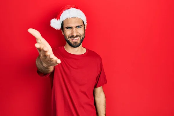 Genç Spanyol Adam Noel Şapkası Takıp Gülümseyerek Selamlaşma Dostça Tokalaşma — Stok fotoğraf