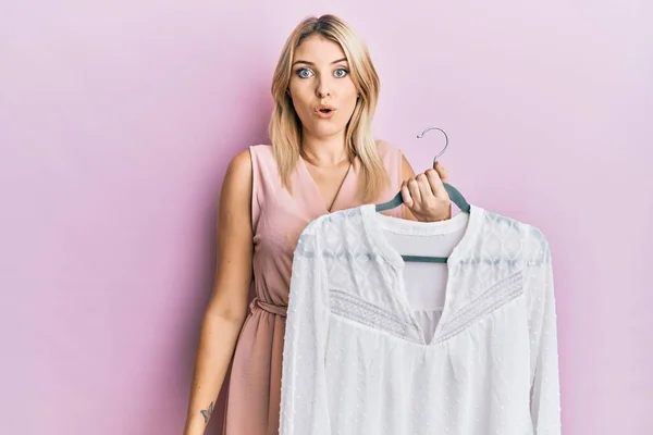 Genç Beyaz Bir Kadın Elinde Gömleği Olan Bir Askı Tutuyor — Stok fotoğraf