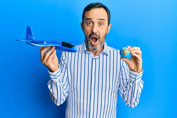 Middle Age Hispanic Man Holding Plane Toy World Ball Afraid — Stock Photo, Image