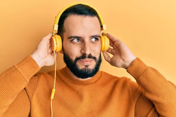 Junger Mann Mit Bart Hört Musik Über Kopfhörer Lächelt Zur — Stockfoto