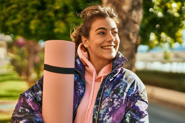 Joven Deportista Hispana Sonriendo Feliz Sosteniendo Esterilla Yoga Parque —  Fotos de Stock