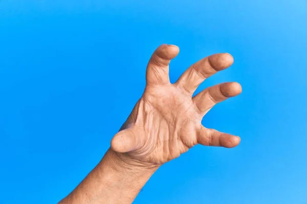 Mano Hombre Hispano Mayor Sobre Fondo Azul Aislado Agarrando Agresivo — Foto de Stock