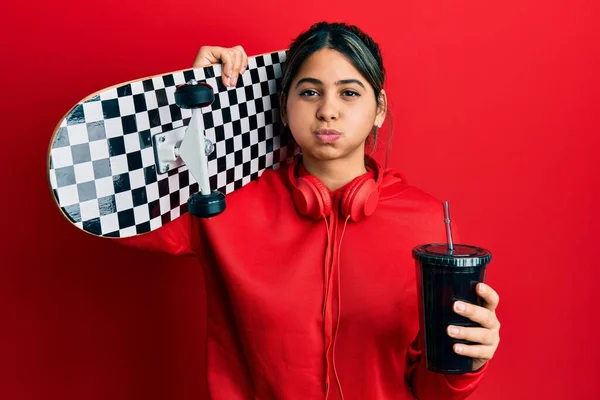 Jovem Latina Segurando Skate Bebendo Refrigerante Bochechas Inchadas Com Cara — Fotografia de Stock