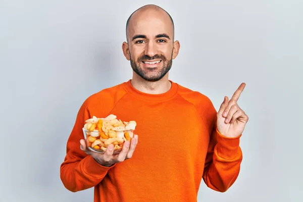 Jonge Kale Man Houdt Aardappel Chip Glimlachend Gelukkig Wijzend Met — Stockfoto