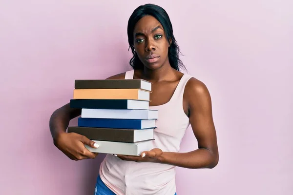 Ung Afrikansk Amerikansk Kvinna Håller Böcker Skeptiska Och Nervösa Rynkar — Stockfoto