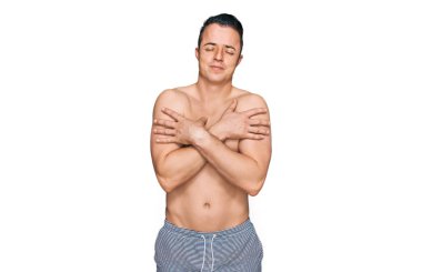 Mayo giyen yakışıklı genç adam mutlu ve pozitif, kendinden emin gülümseyen birine sarılıyor. Sevgi ve özgüven. 