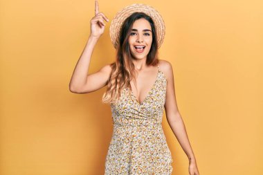 Yaz şapkası takan genç İspanyol kız başarılı bir fikri işaret ediyor. Heyecanlı ve mutlu. Bir numara.. 