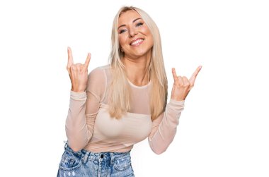 Sıradan kıyafetler giyen, çılgın bir ifadeyle bağıran genç sarışın kadın elleri havada rock sembolü yapıyor. Müzik yıldızı. ağır kavram. 