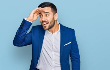 Genç İspanyol bir adam iş ceketi giyiyor çok mutlu ve gülümsüyor. Çok uzaklara bakıyor. arama kavramı. 