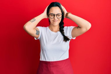 Genç İspanyol kadın garson önlüğü giyiyor. Baş ağrısı çekiyor, çaresiz ve stresli. Çünkü acı ve migren ağrısı var. Eller başının üstünde.. 