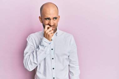 Günlük kıyafetler giyen genç İspanyol adam gergin ve gergin görünüyor. Ağzı tırnak yiyen eller. anksiyete. 