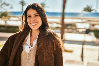 Genç İspanyol kadın gülümseyerek şehirde mutlu mesut dikiliyor..