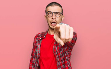 Latin asıllı genç adam, sıradan kıyafetler giyip kameraya kızgın ve sinirli bir şekilde seni işaret ediyor. 