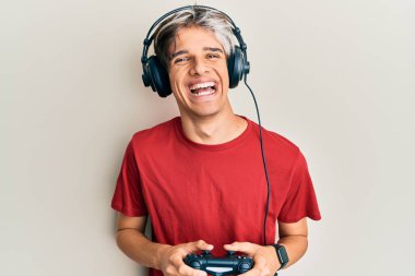 İspanyol asıllı genç bir adam video oyunu oynuyor. Kumandayı tutuyor ve kahkahalarla gülüyor.. 