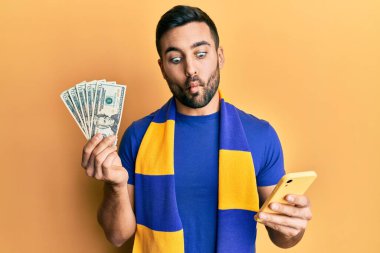 Genç İspanyol futbolcu destekçisi Amerikan dolarlarını elinde tutarak balık suratlı ve şaşı gözlü çılgın ve komik bakışlar atıyor.. 