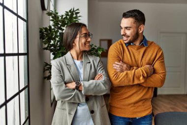 İki iş adamı gülümsüyor. Kollarını kavuşturup ofiste mutlu mesut duruyorlar..