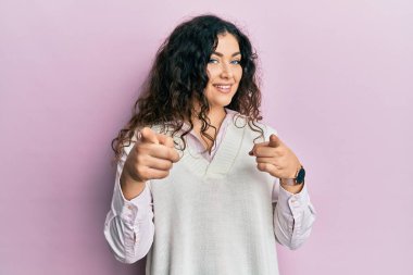 Genç esmer, kıvırcık saçlı, günlük kıyafetler giyen mutlu ve komik yüzlü bir kadın. iyi enerji ve titreşimler. 