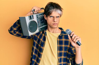 Genç İspanyol adam mikrofon ve teyp kullanarak şarkı söylüyor. Kuşkucu ve gergin. Sorunlar yüzünden surat asıyor. negatif kişi. 