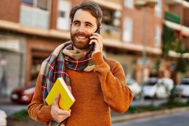 Beyaz sakallı bir adam güneşli bir günde telefonda konuşuyor.