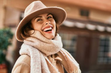 Şık giyinen genç İspanyol kadın şehirde dikiliyor..