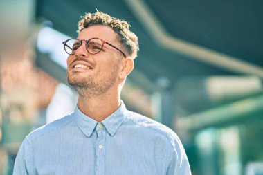 Genç İspanyol işadamı gülümseyerek şehirde mutlu mesut duruyor..