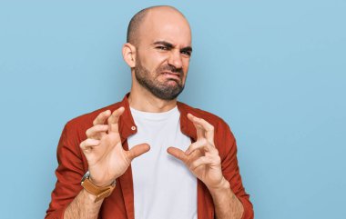 Gündelik kıyafetler giyen genç İspanyol adam tiksinti ifadesi takındı, tiksinti tepkisi yüzünden tiksinti ve korku dolu bir ifade takınıyordu. Eller havada. 