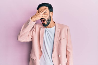 Genç İspanyol bir adam iş ceketi giyiyor. Şoka girmiş, yüzünü ve gözlerini kapamış, utangaç ifadesiyle parmaklarından bakıyor.. 