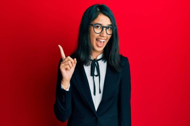İş elbisesi giymiş güzel Asyalı genç bir kadın başarılı bir fikri işaret ediyor. Heyecanlı ve mutlu. Bir numara.. 