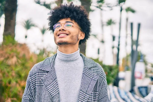 Genç Afrikalı Amerikalı işadamı parkta mutlu bir şekilde dikiliyor.