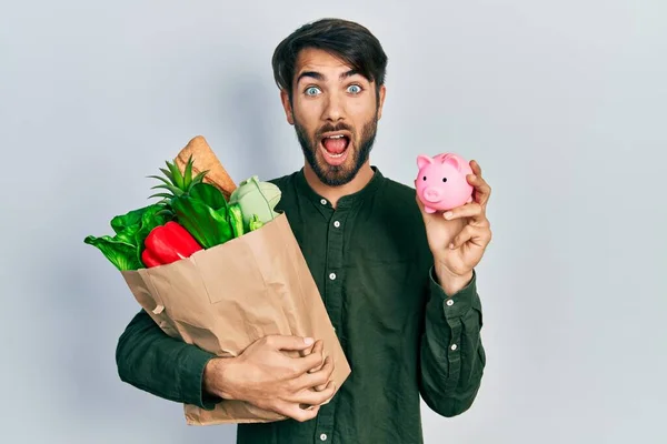 Giovane Uomo Ispanico Che Tiene Salvadanaio Sacchetto Carta Con Generi — Foto Stock