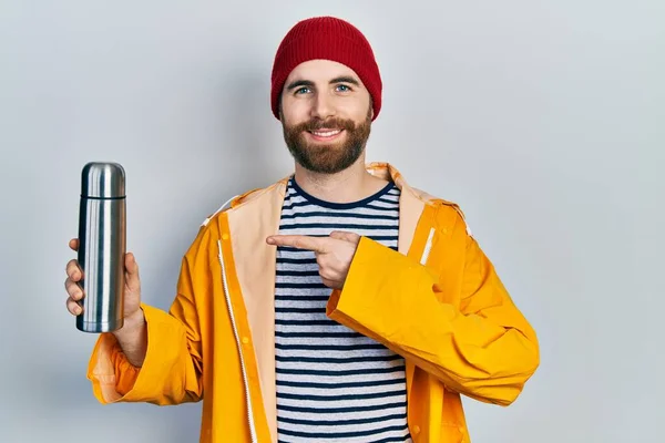 Caucásico Hombre Con Barba Sosteniendo Termo Sonriendo Feliz Señalando Con —  Fotos de Stock