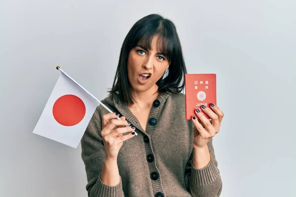 Ung Latinamerikansk Kvinna Med Japansk Flagga Och Pass Chockansikte Ser — Stockfoto