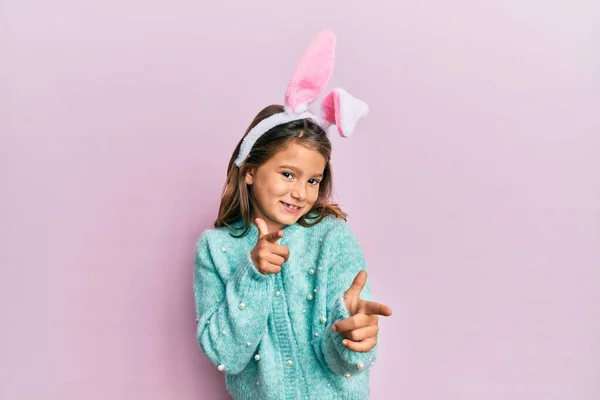 Gyönyörű Kislány Aranyos Húsvéti Nyuszifüleket Visel Ujjal Mutogat Kamerára Boldog — Stock Fotó