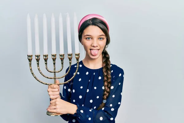 Menina Morena Jovem Segurando Menorah Hanukkah Vela Judaica Colando Língua — Fotografia de Stock