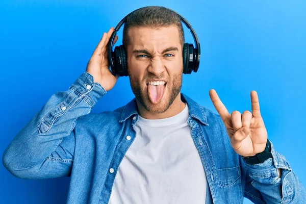 Νεαρός Καυκάσιος Άντρας Που Χρησιμοποιεί Ακουστικά Και Κάνει Ροκ Σύμβολο — Φωτογραφία Αρχείου
