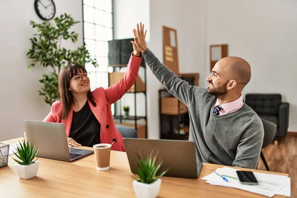 İki İspanyol iş adamı ofiste mutlu bir beşlik çakıyor..