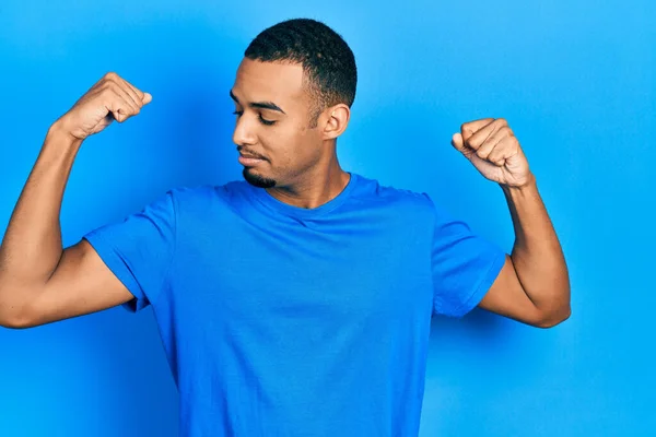 Jovem Afro Americano Vestindo Camisa Azul Casual Mostrando Músculos Dos — Fotografia de Stock