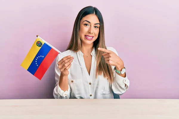 Mladá Hispánka Držící Venezuelskou Vlajku Sedící Stole Šťastně Usmívající Ukazujíc — Stock fotografie