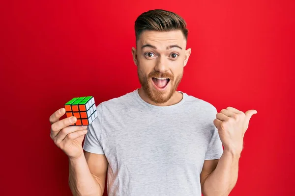 Jovem Ruiva Homem Jogando Colorido Puzzle Cubo Inteligência Jogo Apontando — Fotografia de Stock