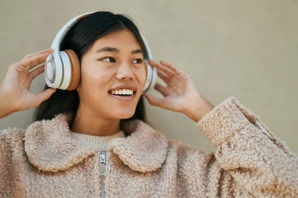 Νεαρή Ασιάτισσα Που Ακούει Μουσική Ακουστικά Στην Πόλη — Φωτογραφία Αρχείου