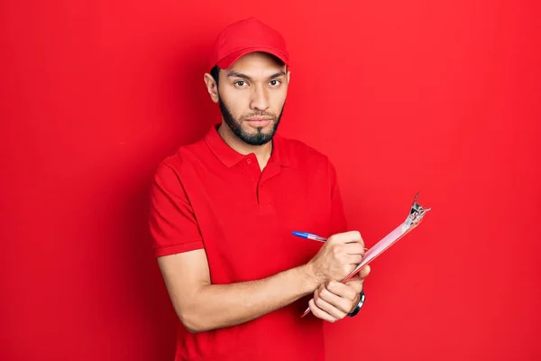 Homem Hispânico Com Barba Vestindo Uniforme Mensageiro Segurando Prancheta Relaxado — Fotografia de Stock